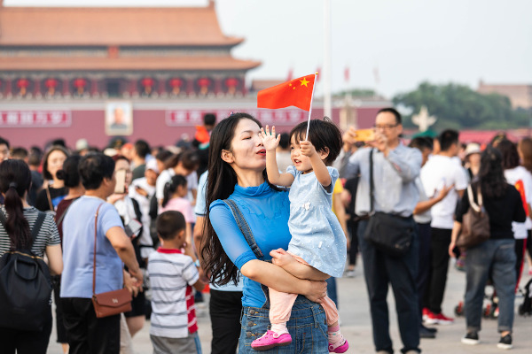 Mulher chinesa segura criança no colo.